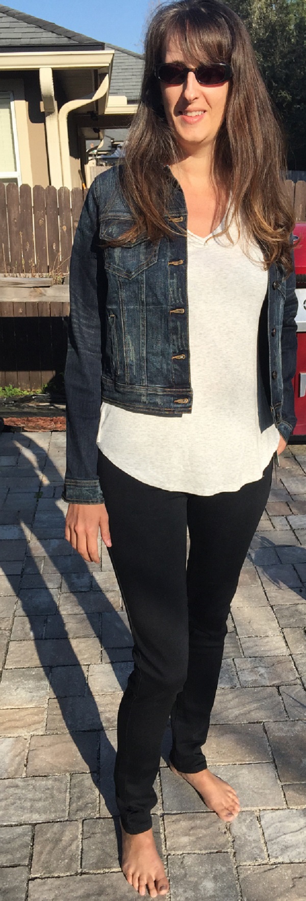 Dark-wash denim jacket paired with cream v-neck tee and black jeans