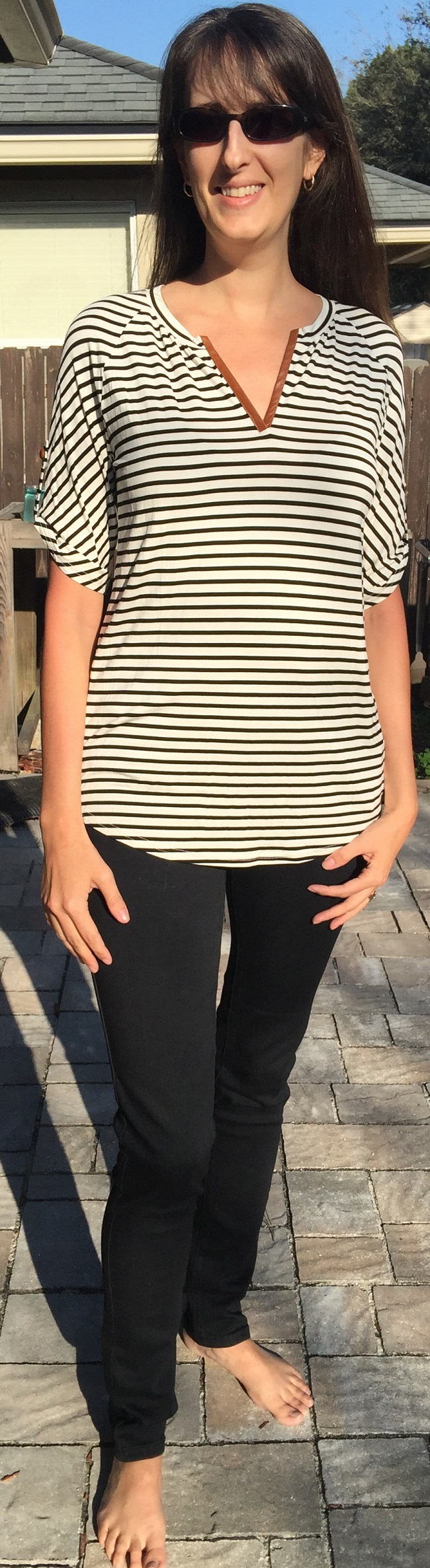 Cream tab-sleeve blouse with thin black horizontal stripes, paired with black pants.
